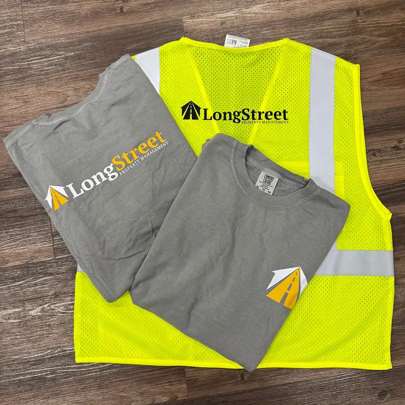 Branded grey tees and a hi-vis safety vest printed for a property management company