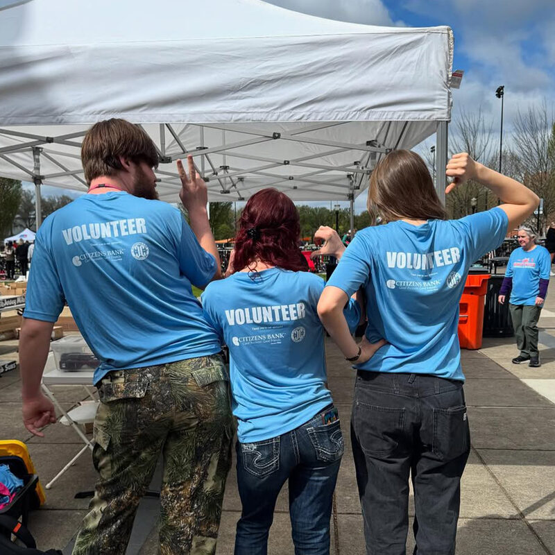 Volunteers wearing custom printed event shirts at an outdoor community event